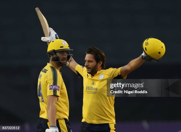 Shahid Afridi of Hampshire celebrates his century with James Vince during the NatWest T20 Blast at The 3aaa County Ground on August 22, 2017 in...