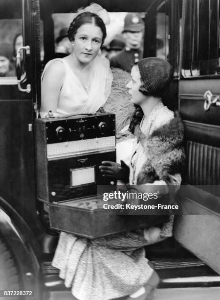 Miss Lloyd-Jones et une amie attendent dans le hall du Palais de Buckingham le début de la saison mondaine en écoutant la radio le 9 juin 1931 à...