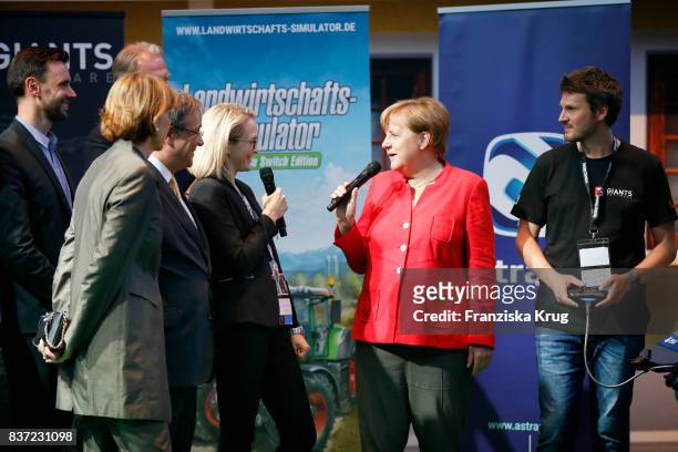 German Chancellor Angela Merkel, Henriette Reker and Armin Laschet visit the Nintendo Switch Edition Agricultural Simulator stand by Astragon with...