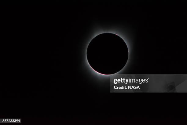 In this NASA handout, the Sun's corona, only visible during the total eclipse, is shown as a crown of white flares from the surface during a total...