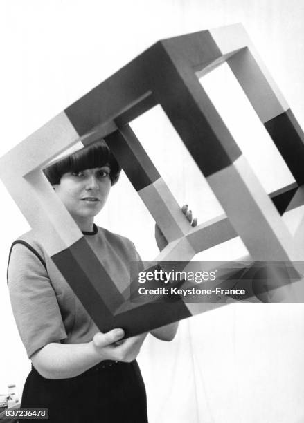 Une femme présente un cube en plastique, oeuvre d'art réalisée par l'artiste allemand Erwin Heerich et exposé à la galerie Schmela le 21 juin 1966 à...