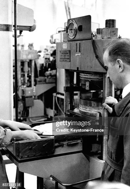 Ovrier pressant un vinyle dans une usine de la société Philips en France en septembre 1957.