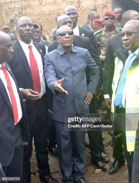 Guinea's President Alpha Conde arrives on the site where eight people died and dozens were injured in the West African state of Guinea when a rubbish...