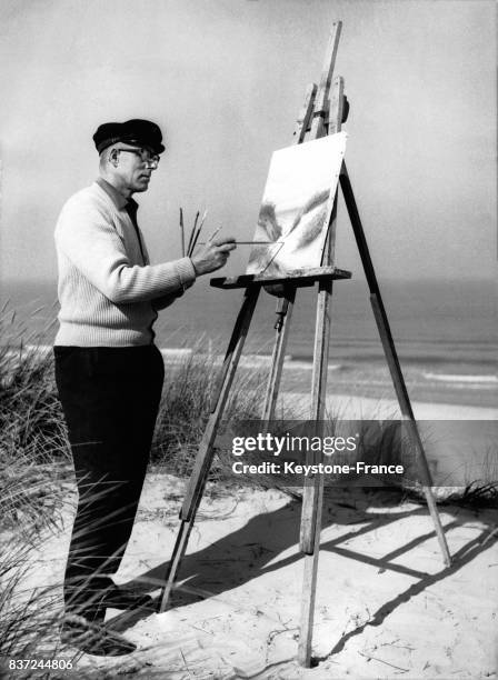 Le peintre des îles de la Mer du Nord Dirks peint la mer avec ses pinceaux le 8 octobre 1964.
