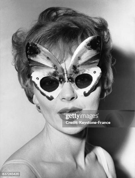 Une jeune femme présente un modèle de lunettes originales.