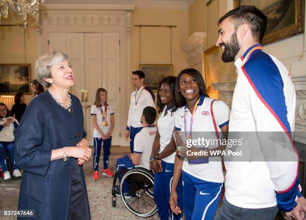 British Prime Minister Theresa May speaks to Asha Philip, Perri Shakes-Drayton and Martyn Rooney during a reception for who competed in the World...