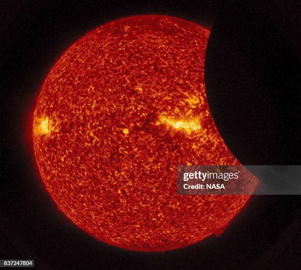 In this NASA handout, the Moon transits across the Sun, as seen in 304 angstrom extreme ultraviolet light during the total eclipse Monday, August 21,...