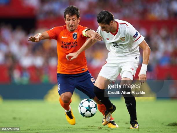 Sergio Escuderoof Sevilla FC competes for the ball with Edin Visca of Istanbul Basaksehir during the UEFA Champions League Qualifying Play-Offs round...