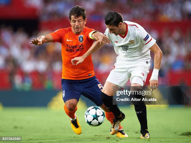 Sergio Escuderoof Sevilla FC competes for the ball with Edin Visca of Istanbul Basaksehir during the UEFA Champions League Qualifying Play-Offs round...