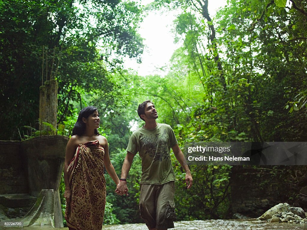 Couple exploring ruins in jungle