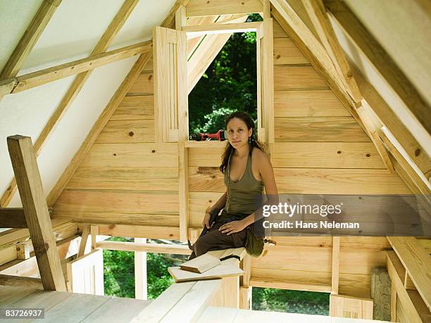 young woman building new home in forest - ヒリトラ ストックフォトと画像