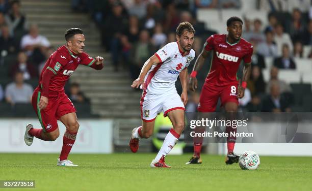 Ed Upson of Milton Keynes Dons moves away with the ball from Roque Mesa of Swansea City during the Carabao Cup Second Round match between Milton...