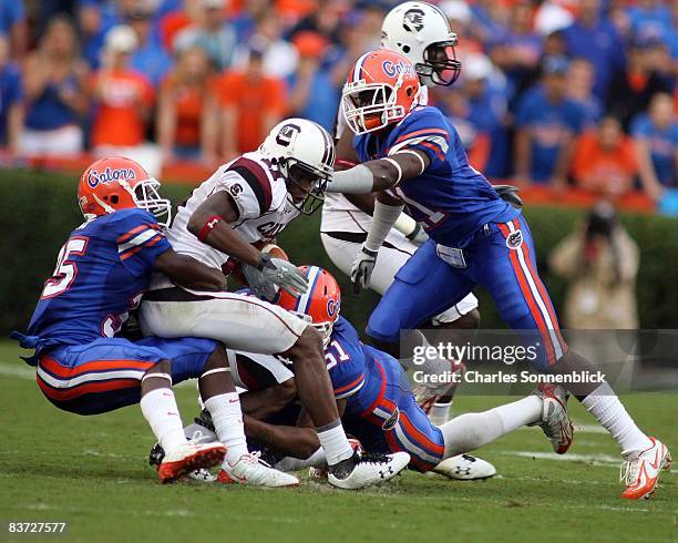 Wide Receiver Kenny Mckinley of the South Carolina Gamecocks catches a quick slant pass and is tackled by safety Ahmad Black safety Major Wright and...