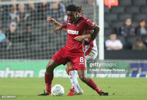 Leroy Fer of Swansea City is challenged by Ed Upson of MK Dons during the Carabao Cup Second Round match between MK Dons and Swansea City at...