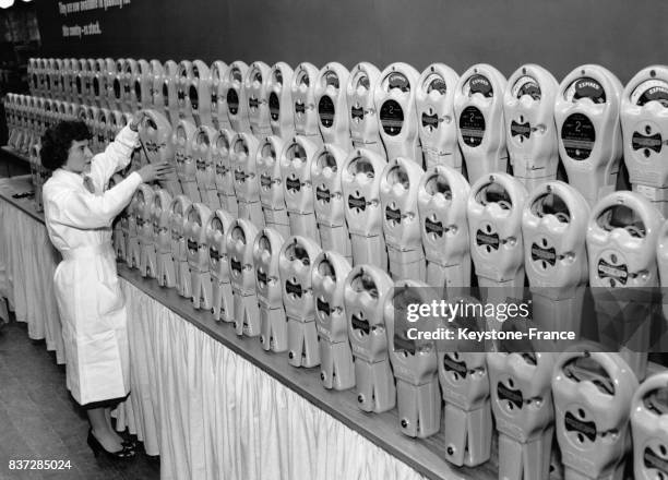 Une employée prépare des parcmètres en prévision de l'exposition consacrée aux services municipaux le 12 novembre 1956 à New Malden, Royaume-Uni.