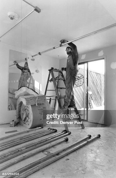 Bill Thompson, an employee of Frontier Fire Protection Inc., installs a sprinkler system in the coed lounge area of the new Boulder Shelter for the...