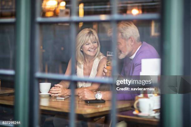mature couple having a drink in a pub - london pub stock pictures, royalty-free photos & images
