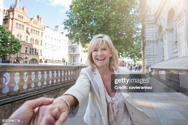 ロンドンで楽しんで笑顔の熟女 - 手を引く ストックフォトと画像