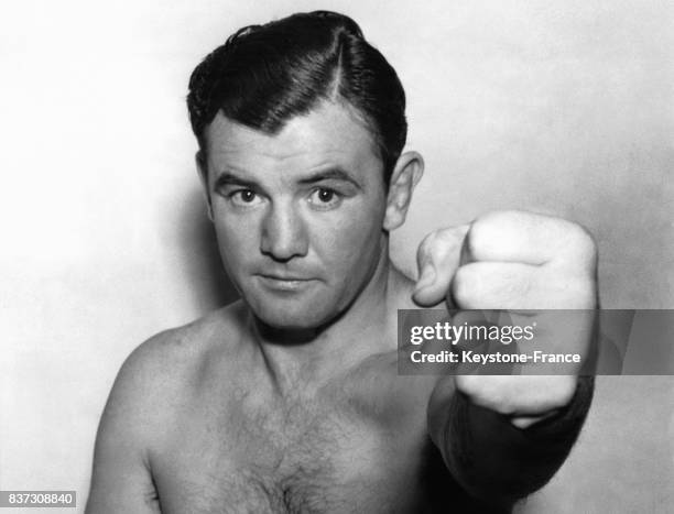 Le boxeur Jimmy Braddock brandit son poing pour indiquer qu'il est de nouveau apte au combat après une blessure à la main le 23 novembre 1936 à New...