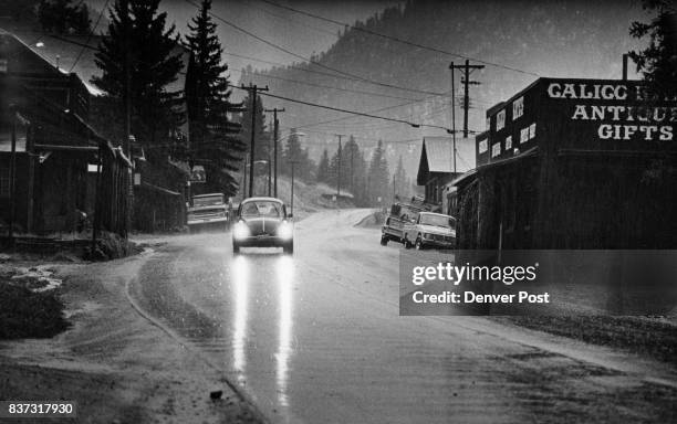 An automobile moves through the village of Glen Haven on the North Fork of Big Thompson River during a rainstorm that had caused some worry. The area...