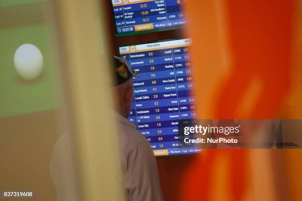 Elderly man is seen looking at screens in a betting shop on 19 August in Bydgoszcz, Poland.