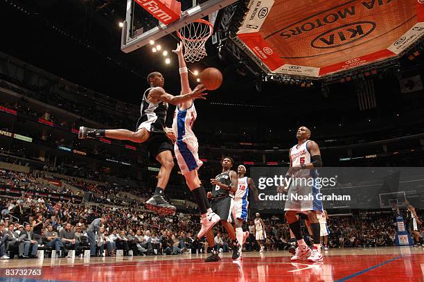 George Hill of the San Antonio Spurs makes a pass around Chris Kaman of the Los Angeles Clippers at Staples Center on November 17, 2008 in Los...