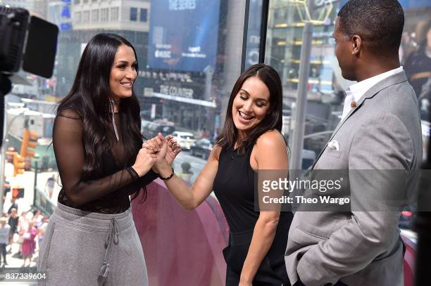 Nikki Bella, Brie Bella and AJ Calloway during a taping of The Bella Twins Visit "Extra" at H&M Times Square on August 22, 2017 in New York City.