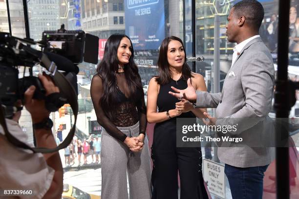 Nikki Bella, Brie Bella and AJ Calloway during a taping of The Bella Twins Visit "Extra" at H&M Times Square on August 22, 2017 in New York City.