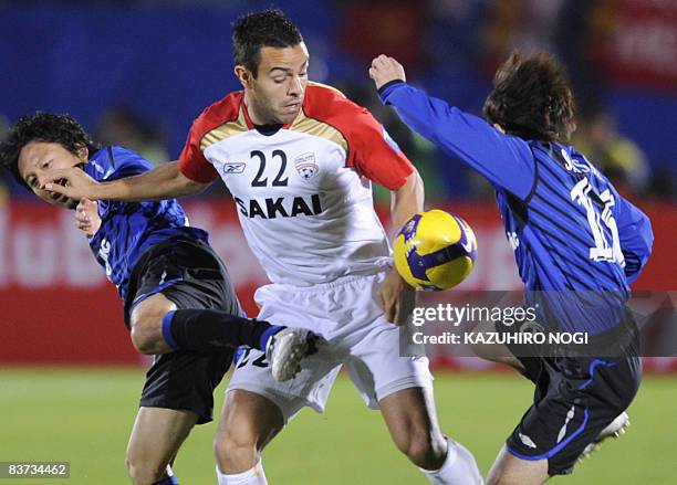 Australia's Adelaide United defender Diego Walsh fights for the ball with Japan's Gamba Osaka midfielder Hideo Hashimoto and midfielder Hayato Sasaki...