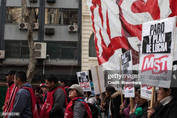 Demonstrators hold signs during a protest in Buenos Aires, Argentina, on Tuesday, Aug. 22, 2017. Union groups protested Argentinean President...