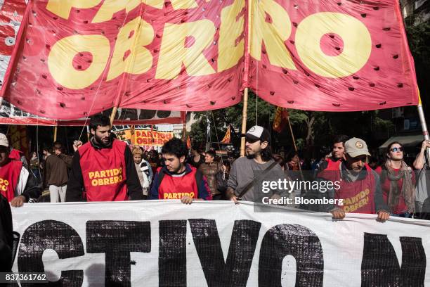 Demonstrators hold signs during a protest in Buenos Aires, Argentina, on Tuesday, Aug. 22, 2017. Union groups protested Argentinean President...