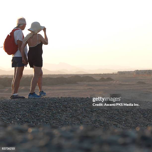 senior couple walk through desert landscape - west asia stock pictures, royalty-free photos & images
