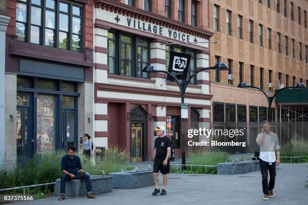 Pedestrians pass in front of the former headquarters for The Village Voice in the East Village neighborhood of New York, U.S., on Tuesday, Aug. 22,...