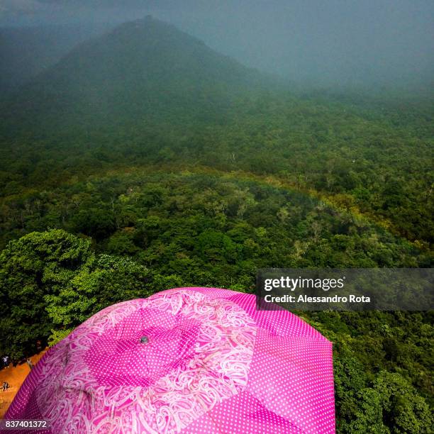 Tourists taking cover from the rain at Sigirya UNESCO site in Srilanka - SriLanka faced a civil war between 1983 and 2009: the 26-year military...