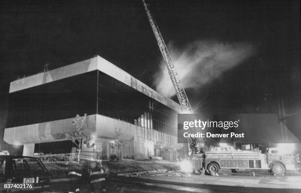 Office Complex Fire -- A ladder truck stands ready as firefighters combat a multi-alarm blaze inside the roof of an office complex at Academy...