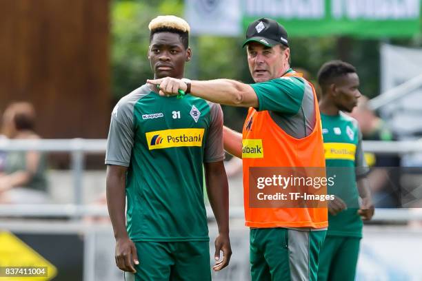 Head coach Dieter Hecking of Borussia Moenchengladbach speak with Ba-Muaka Simakala of Borussia Moenchengladbach during a training session at the...