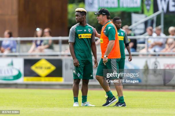 Head coach Dieter Hecking of Borussia Moenchengladbach speak with Ba-Muaka Simakala of Borussia Moenchengladbach during a training session at the...