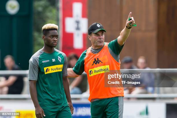 Head coach Dieter Hecking of Borussia Moenchengladbach speak with Ba-Muaka Simakala of Borussia Moenchengladbach during a training session at the...