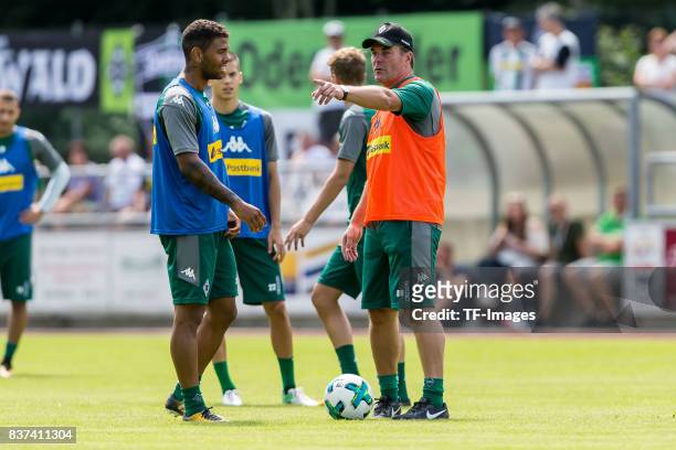 Head coach Dieter Hecking of Borussia Moenchengladbach speak with Kwame Yeboah of Borussia Moenchengladbach during a training session at the Training...