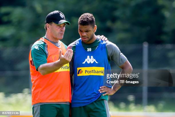 Head coach Dieter Hecking of Borussia Moenchengladbach speak with Kwame Yeboah of Borussia Moenchengladbach during a training session at the Training...