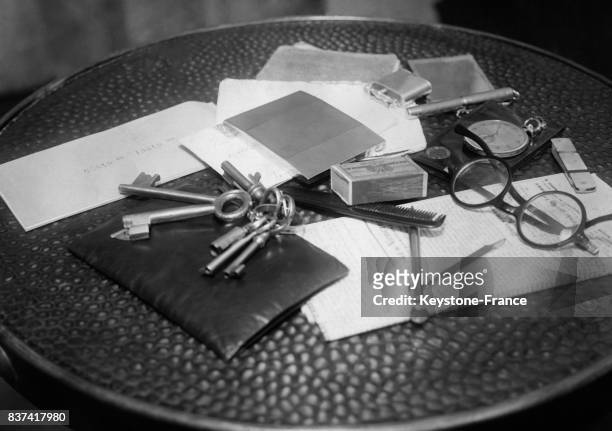 Les objets qu'un homme utilise au quotidien: un peigne, une paire de lunettes, un trousseau de clés, un portefeuille, une montre à gousset, une...