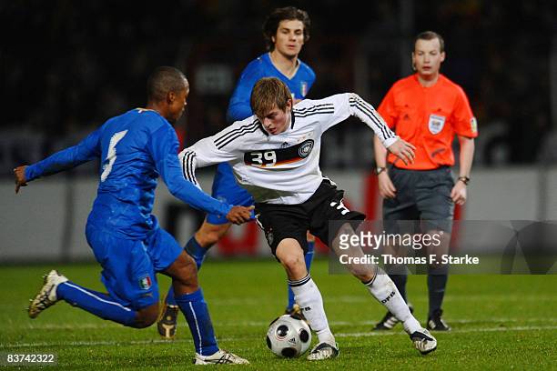 Fabiano Santacroce and Daniele Dessena of Italy tackle Toni Kroos of Germany during the men's U21 international friendly match between Germany and...