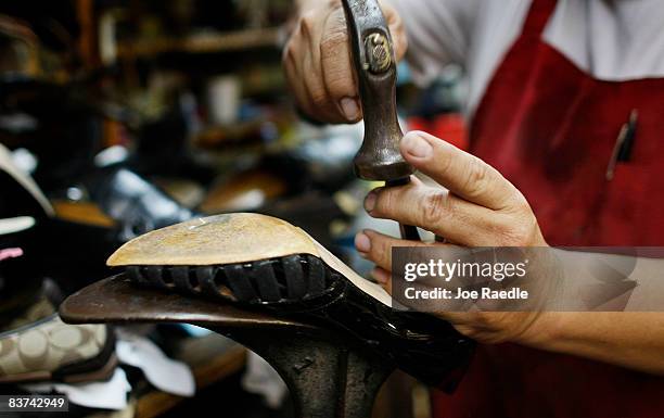 Nicholas Cammarata works on repairing a shoe at Adams Shoe Service Shop November 18, 2008 in Surfside, Florida. Store owner Tina Cammarata say's she...