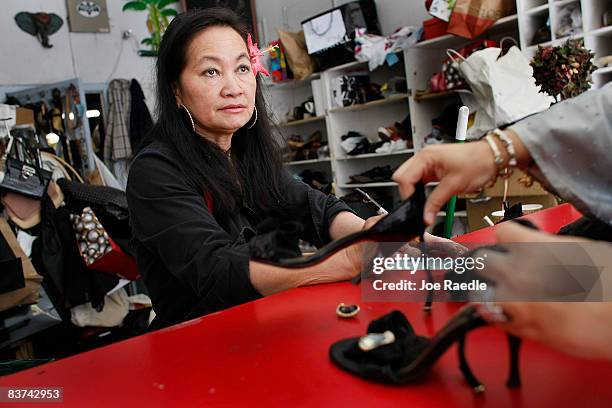 Tina Cammarata takes in a pair of shoes from a customer at Adams Shoe Service Shop November 18, 2008 in Surfside, Florida. Tina say's she has seen an...