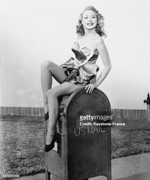Une belle jeune femme assise sur une boîte aux lettres aux Etats-Unis.
