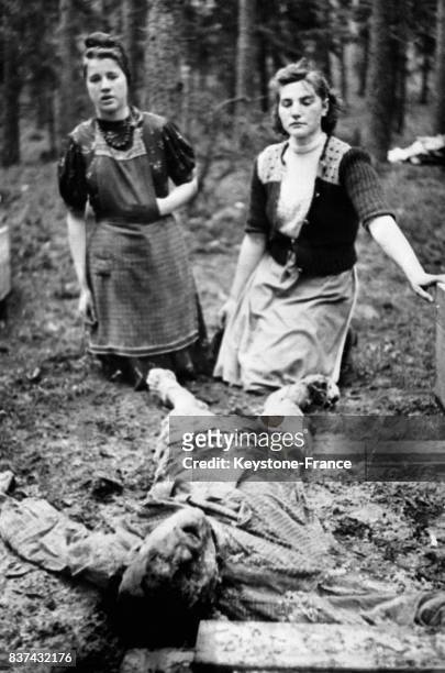Deux femmes allemandes devant un cadavre torturé dans un camp de concentration en Allemagne en 1945.