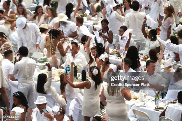 Thousands of diners wave their napkins at the start of the annual "Diner en Blanc" at Lincoln Center on August 22, 2017 in New York City. Diner en...