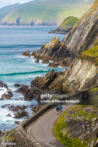 tourists at coumeenoole beach. slea head, ireland. - verwaltungsbezirk county kerry stock-fotos und bilder