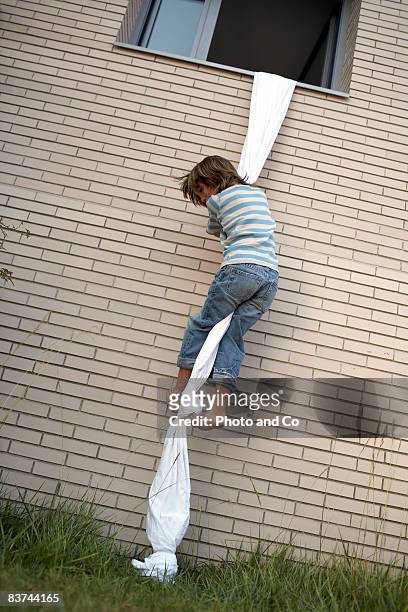 ragazzi arrampicate fuori della finestra utilizzando foglio di corda - fuggire foto e immagini stock