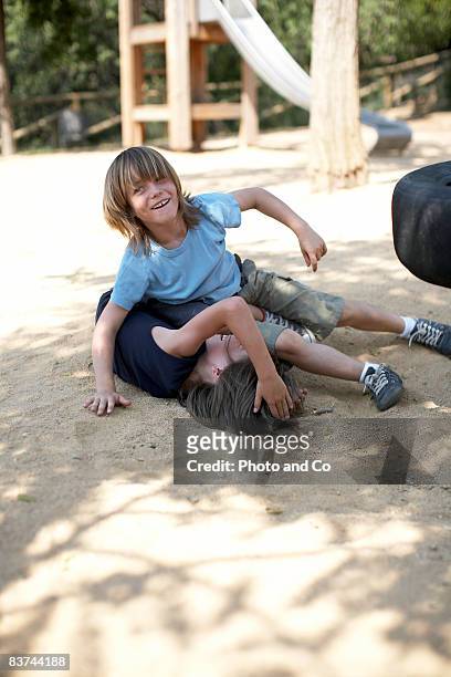 boys wrestle in park - boys wrestling stock pictures, royalty-free photos & images